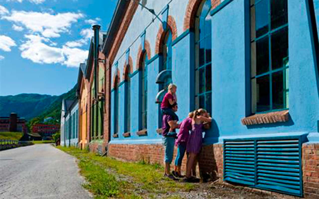 Barn som kikker inn vinduet på en fabrikk i Rjukan