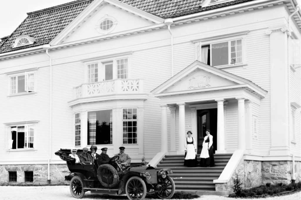 Mercedes med sjåfør: Samme år som Hydros staselige admini sto klart på Notodden, mottok Sam Eyde en rød Mercedes fra Tyskland. Året etter, i 1907, bestilte han ytterligere to biler fra Tyskland. (Foto: Hydro/NIA).