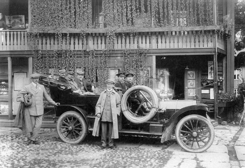 Eydes Mercedes: I 1907, året etter at Sam Eyde kjøpte sin første Mercedes, fikk også Sigurd Kloumann seg tildelt en Mercedes, men her poserer han foran Eydes bil, med egen tysk sjåfør og kong Haakon som passasjer sammen med blant andre admiral Børresen. (Foto: Jenny Arnesen/NIA).
