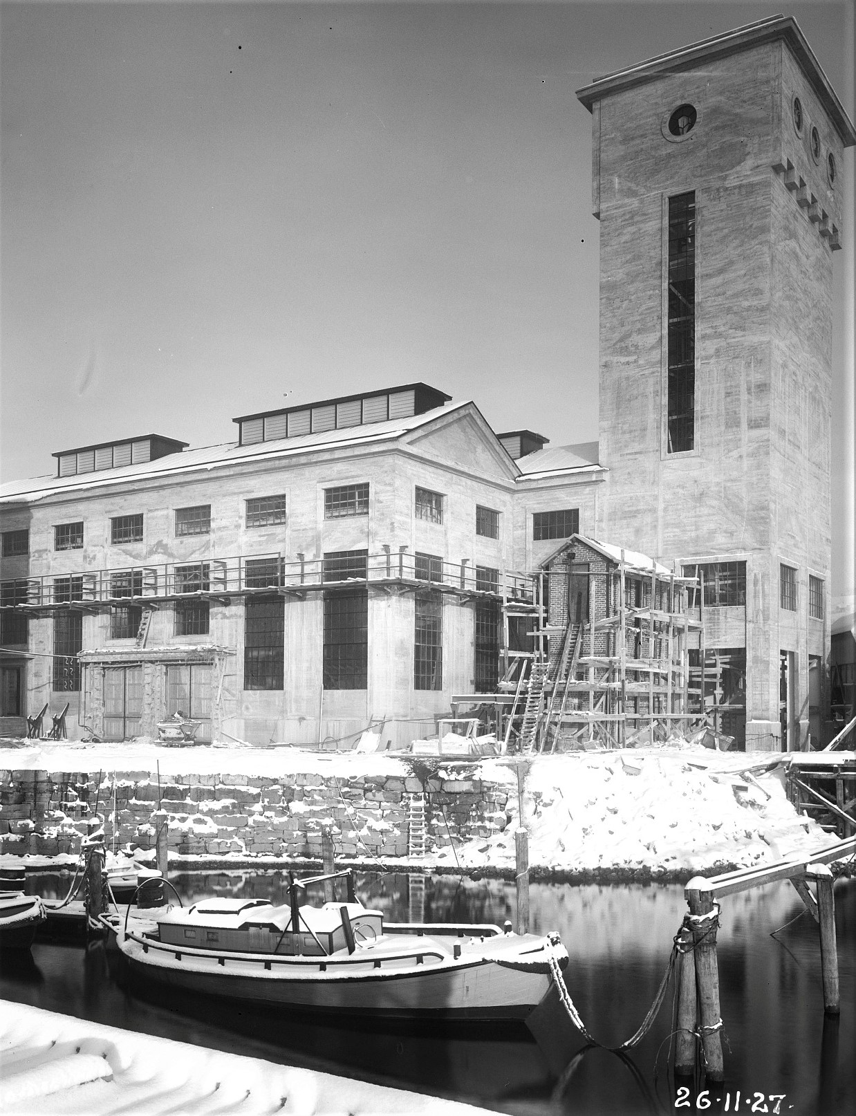 Bygg 130 - ”Syntesen” Oppført 1926 (Arkitekt: Thorvald Astrup). I dette bygget ble nitrogen (N) og hydrogen (H) fra bygg 115 ført sammen for å fremstille ammoniakk (NH3). Ammoniakken ble i flytende form transportert til Herøya. Fabrikkene der laget gjødsel til landbruket. I den høye delen av bygg 130, det karakteristiske tårnet, sto syntese-ovnen. (Foto: Hydro/NIA).