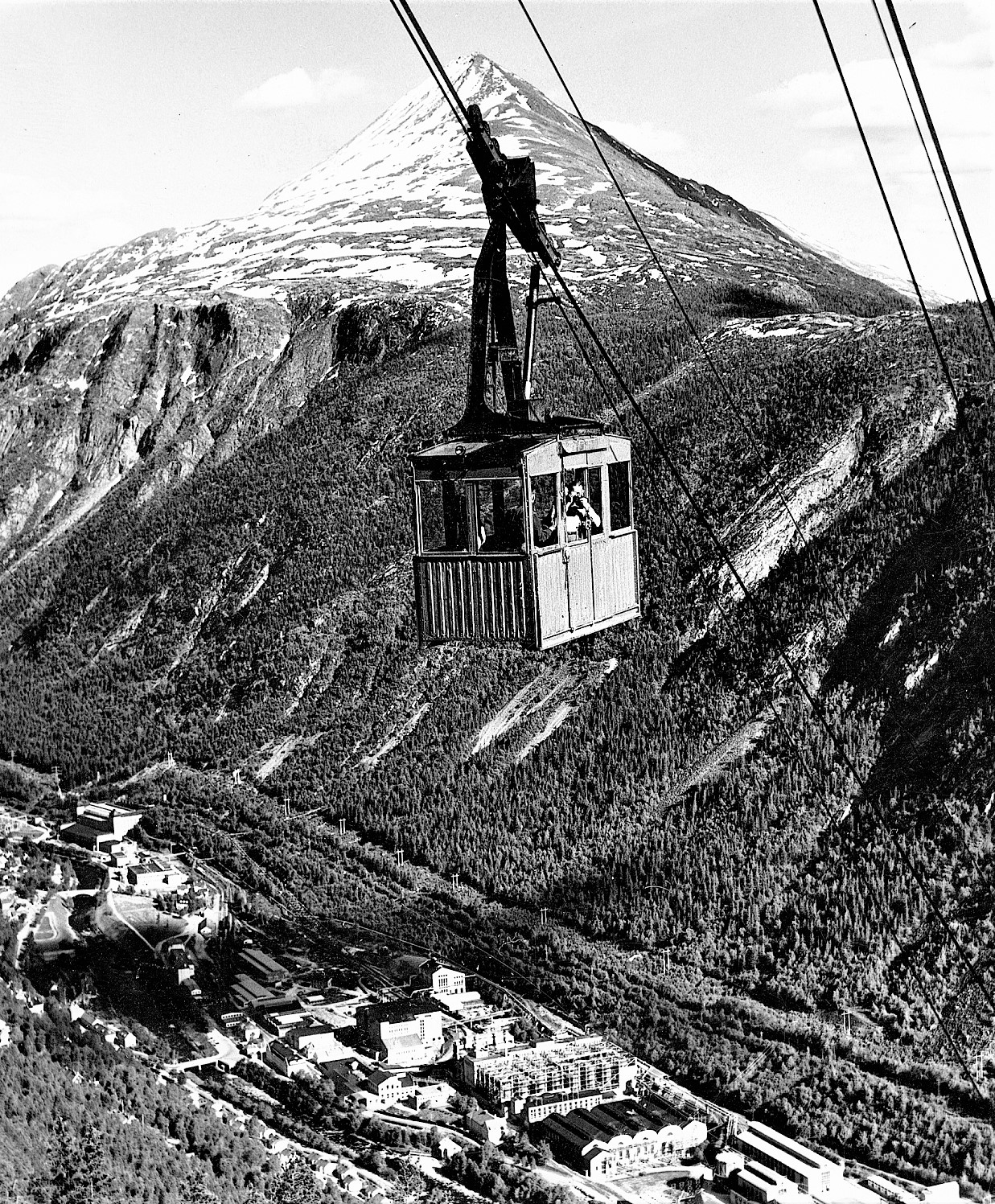 Svever over byen: Den horisontale avstand mellom nedre og øvre stasjon er 814 meter og høydeforskjellen er 498 meter, det vil si at banen stiger 60 centimeter på hver meter. De to vognene går under navnene Blåbæret og Tyttebæret. (Foto: Hydro/NIA).