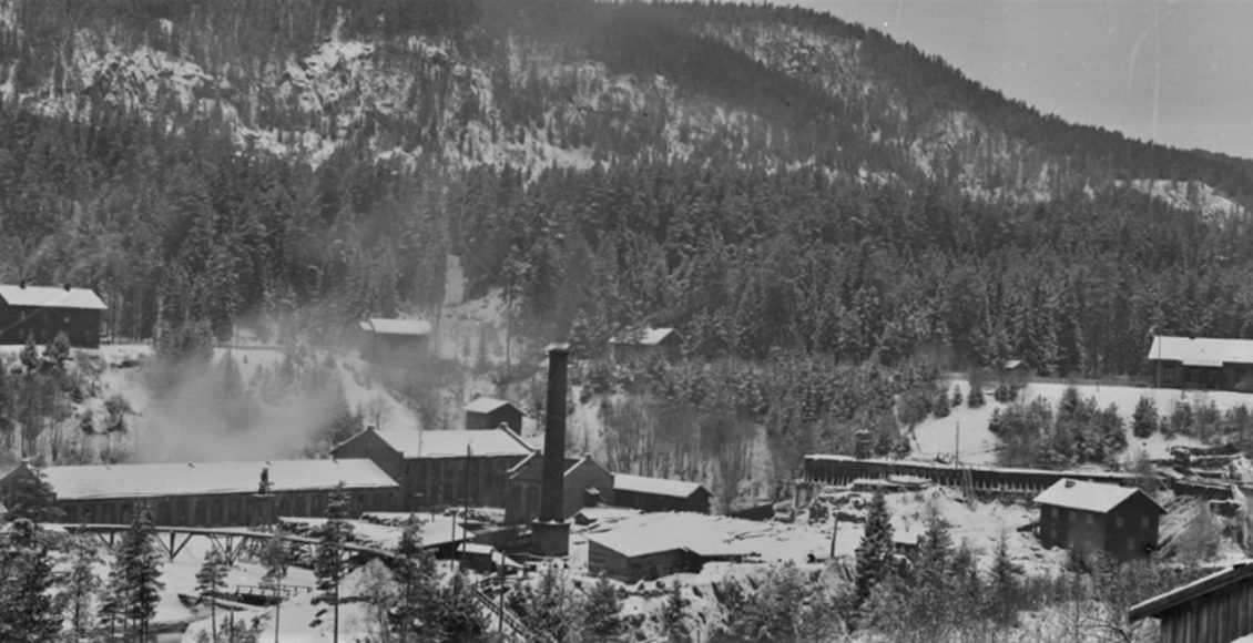 Vatn vart leida til sliperiet: Dette biletet frå 1896 syner eit nedbrent tresliperi, men i bakgrunnen kan me sjå vassrenna som førte vatn fram til tresliperiet. (Foto: Tinfos/NIA).